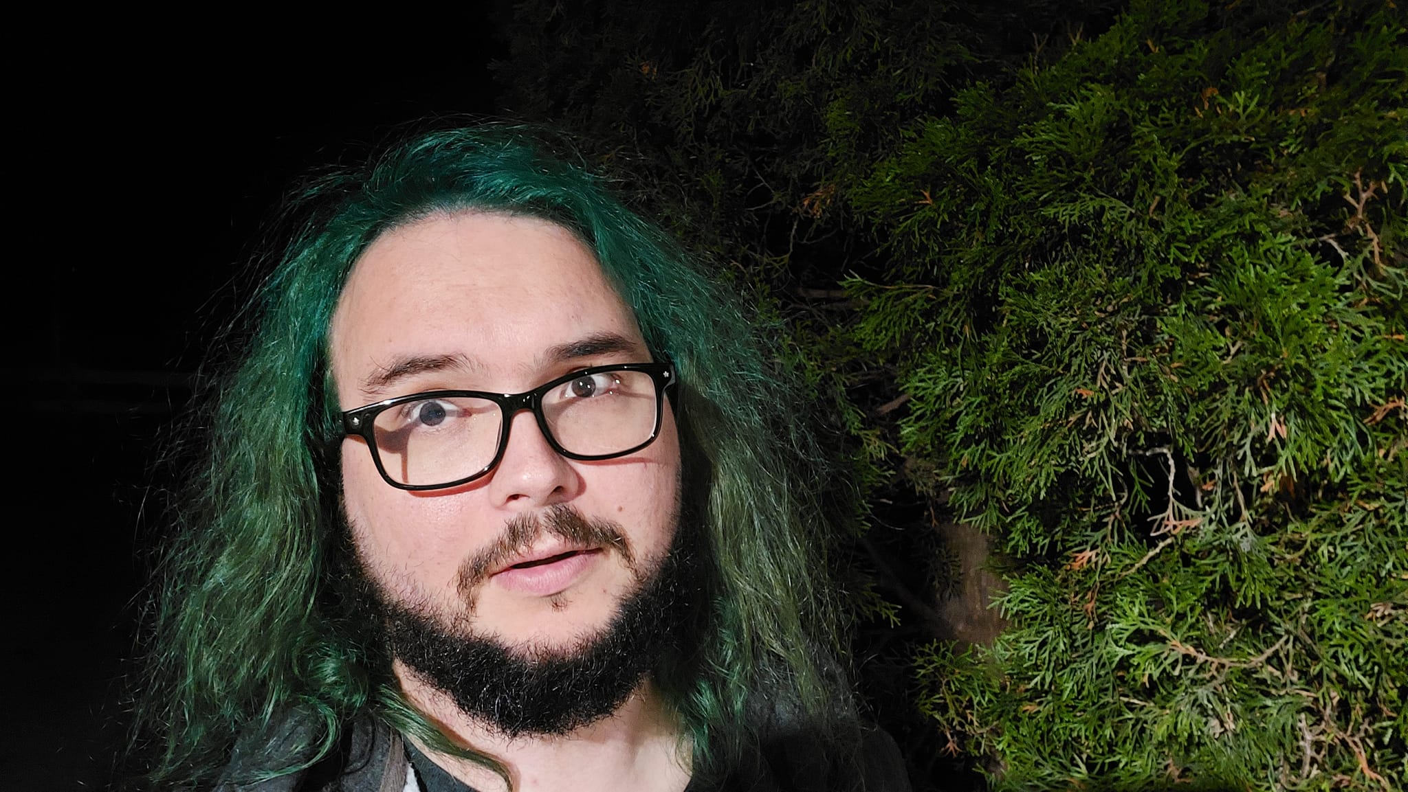 A man with green hair is outside after dark, Photo 10